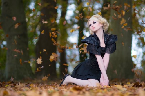 Девушка блондинка в готическом черном платье на фоне листопада