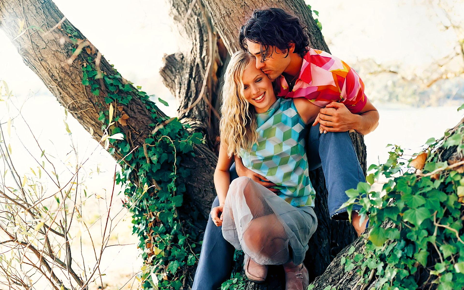 Парень и девушка обнимаются под деревом