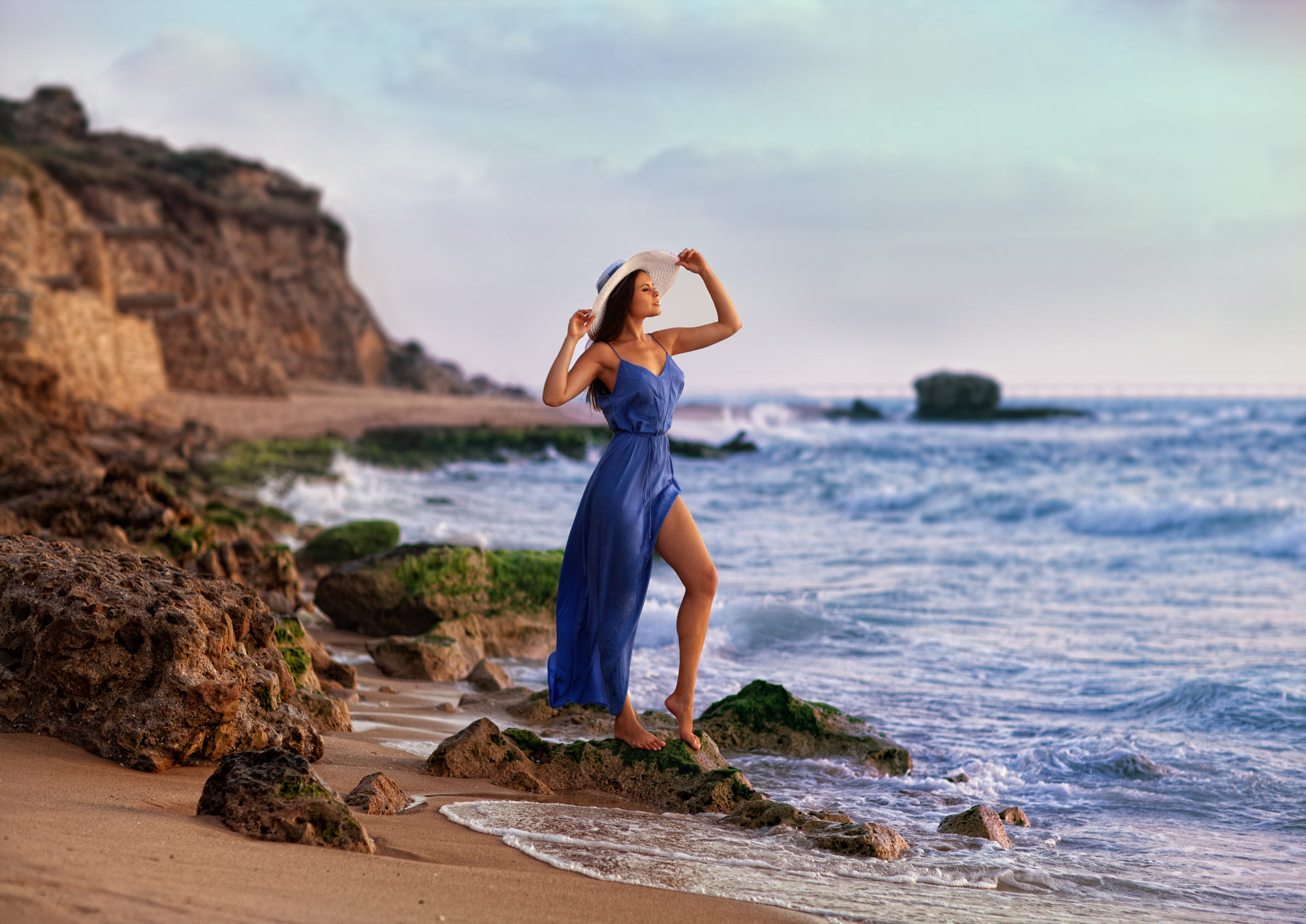 Девушка Марис в шляпе и голубом платье стоит у моря, фотограф Zachar Rise