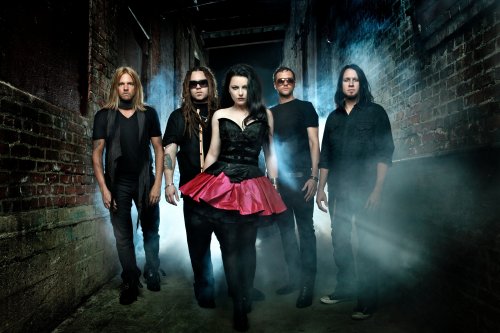Музыкальная группа Evanescence, солистка Amy Lee / Эми Ли, мужчины с девушкой стоят возле кирпичных стен домов, позади них темнота и туман