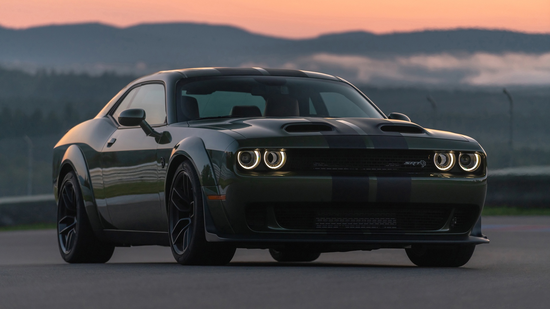 Серый Dodge Challenger SRT Hellcat на фоне гор на закате