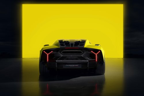 Желтый и черный Lamborghini Fenomeno с красными Y-образными задними фонарями вид сзади, стоит на темном полу