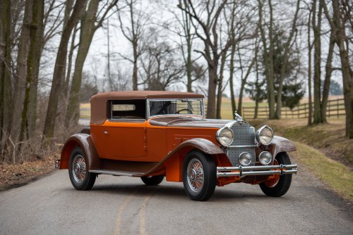 Ретро автомобиль Packard Deluxe Eight Convertible Victoria by Maurice Proux сделанный в единственном экземпляре на фоне деревьев