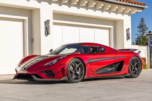 Суперкар красного цвета Koenigsegg Regera на фоне здания
