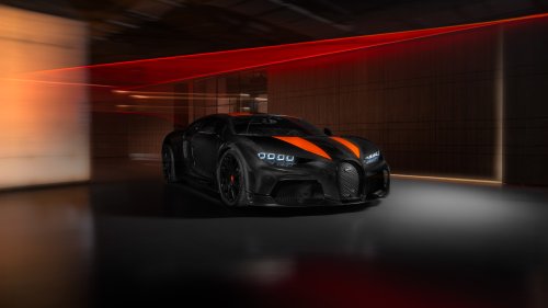 Bugatti Chiron Super Sport 300+ (Bugatti Chiron Super Sport 300+) черного цвета с оранжевыми полосами в темном помещении