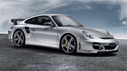 Серый автомобиль Porsche 911 Turbo / Порш 911 Турбо стоит на дороге на фоне неба