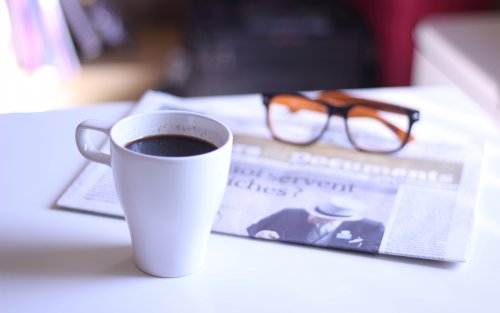Очки, газета и чашка крепкого кофе